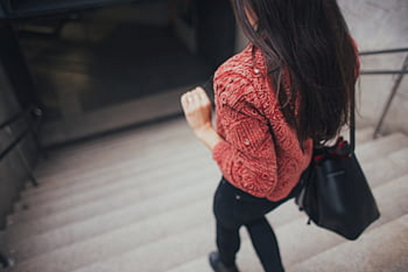 Woman with Black Purse Walking Downstairs